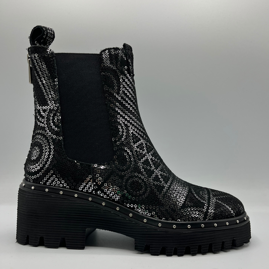 Black sequin boot with a platform sole on a gray background