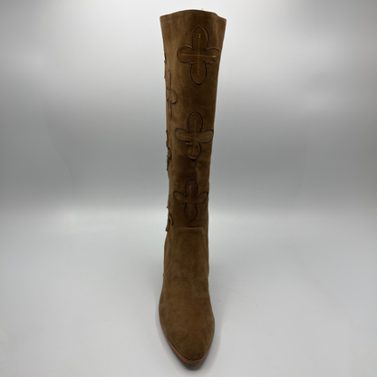 A single knee-high brown suede boot with embossed floral motifs on the shaft, shown against a neutral gray studio background.