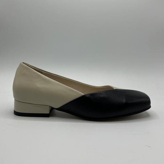Two-tone shoe with beige upper and black sole on a gray background