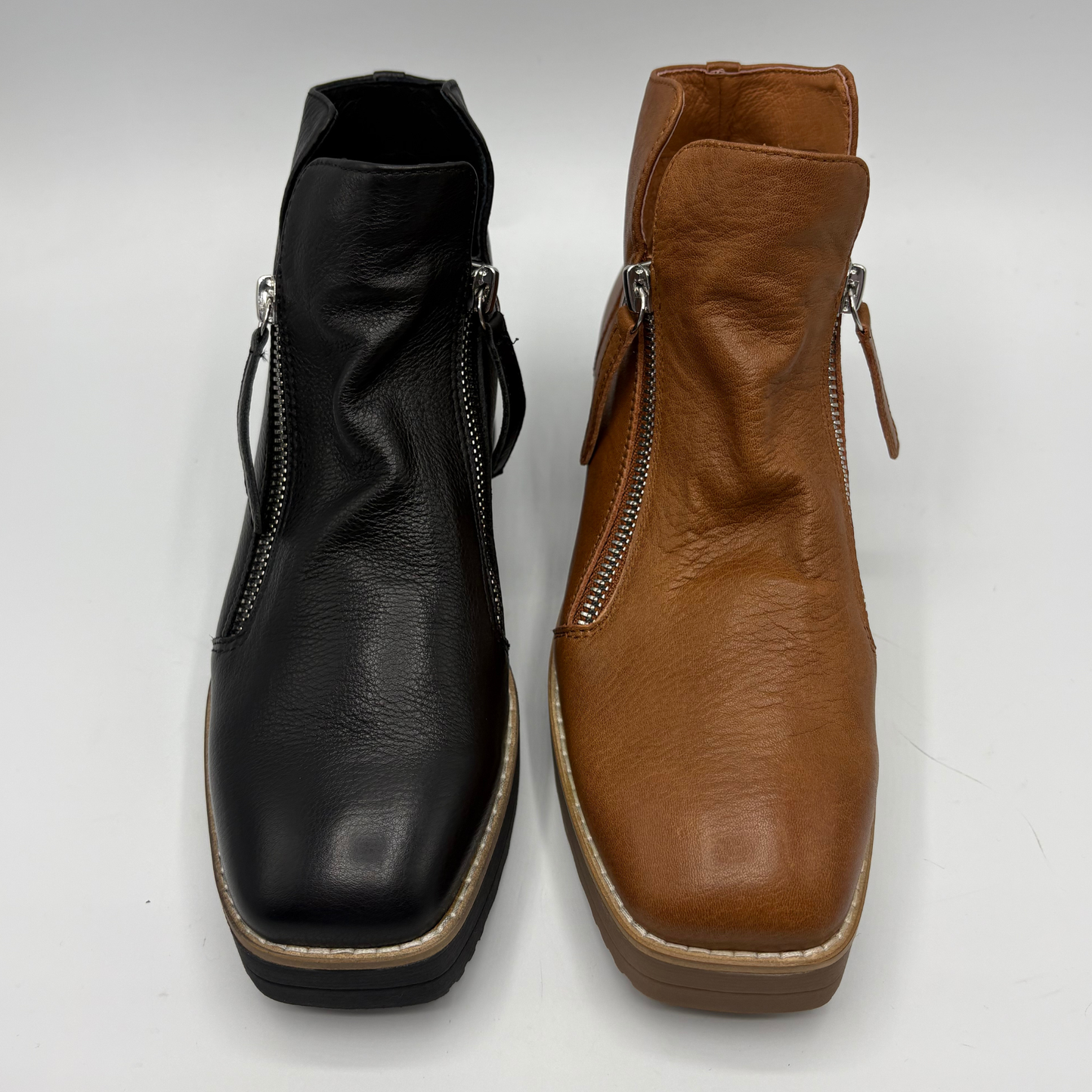 Two ankle boots with side zippers, shown side by side on a light gray background. The boot on the left is black, and the boot on the right is tan brown.