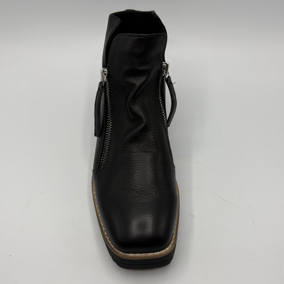A black leather ankle boot with side zippers, a low block heel, and a tan outsole, shown from a top-down view on a white background.