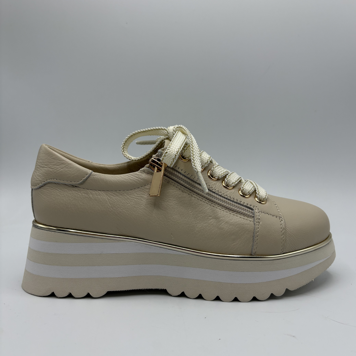 Beige sneaker with white sole on a gray background