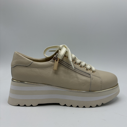 Beige sneaker with white sole on a gray background