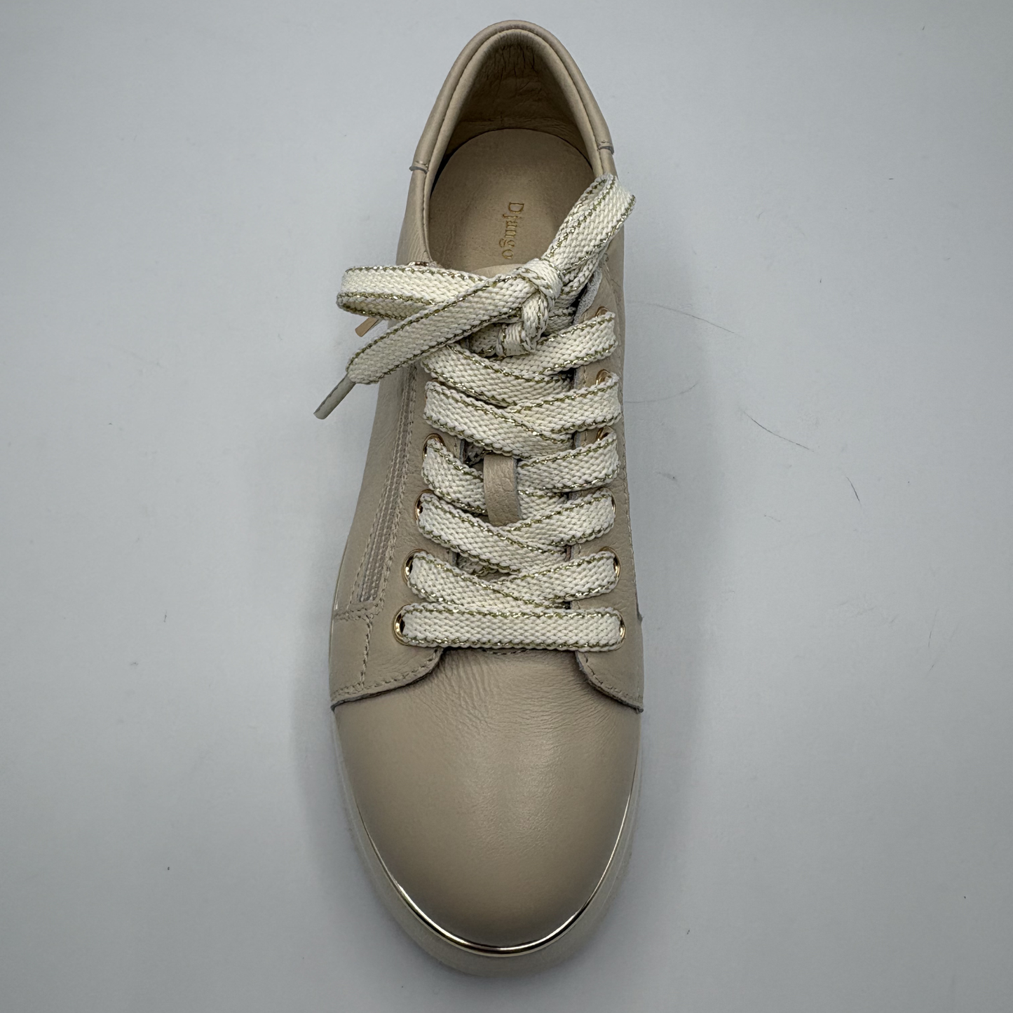 Beige sneaker with white laces on a gray background