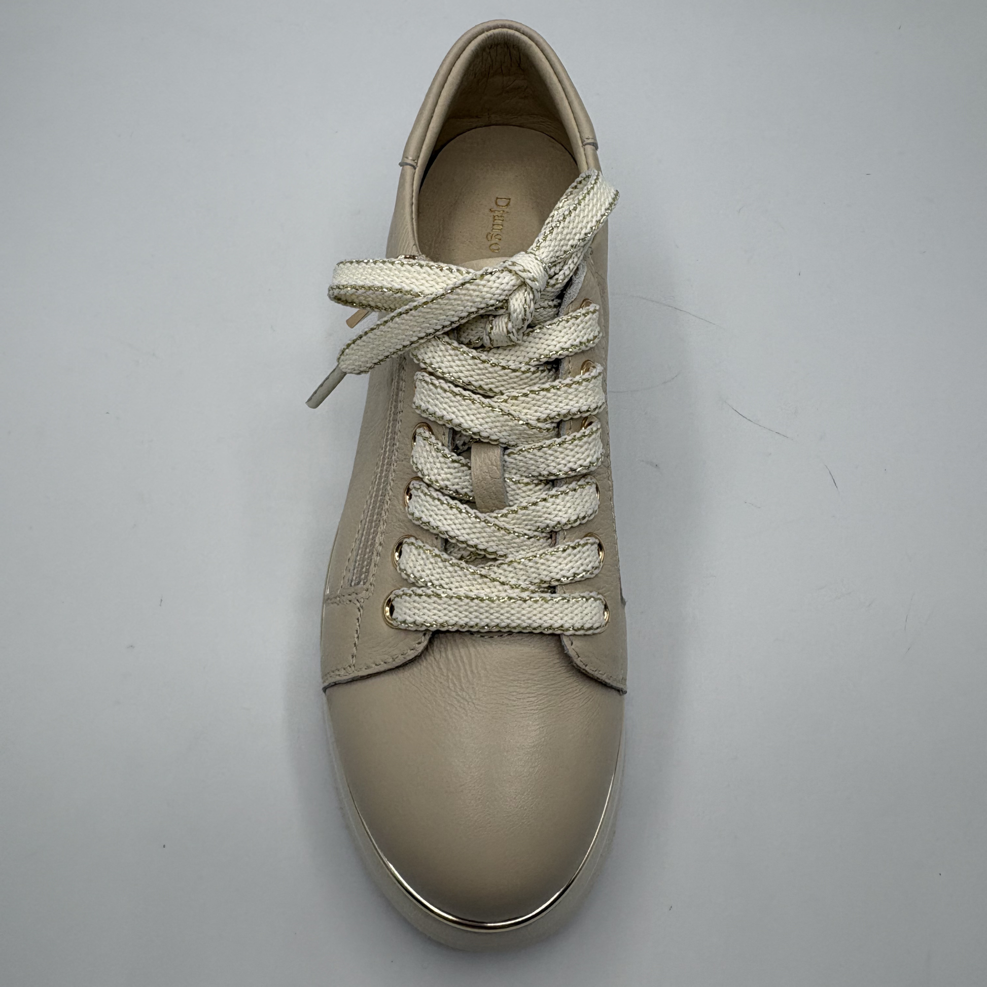 Beige sneaker with white laces on a gray background