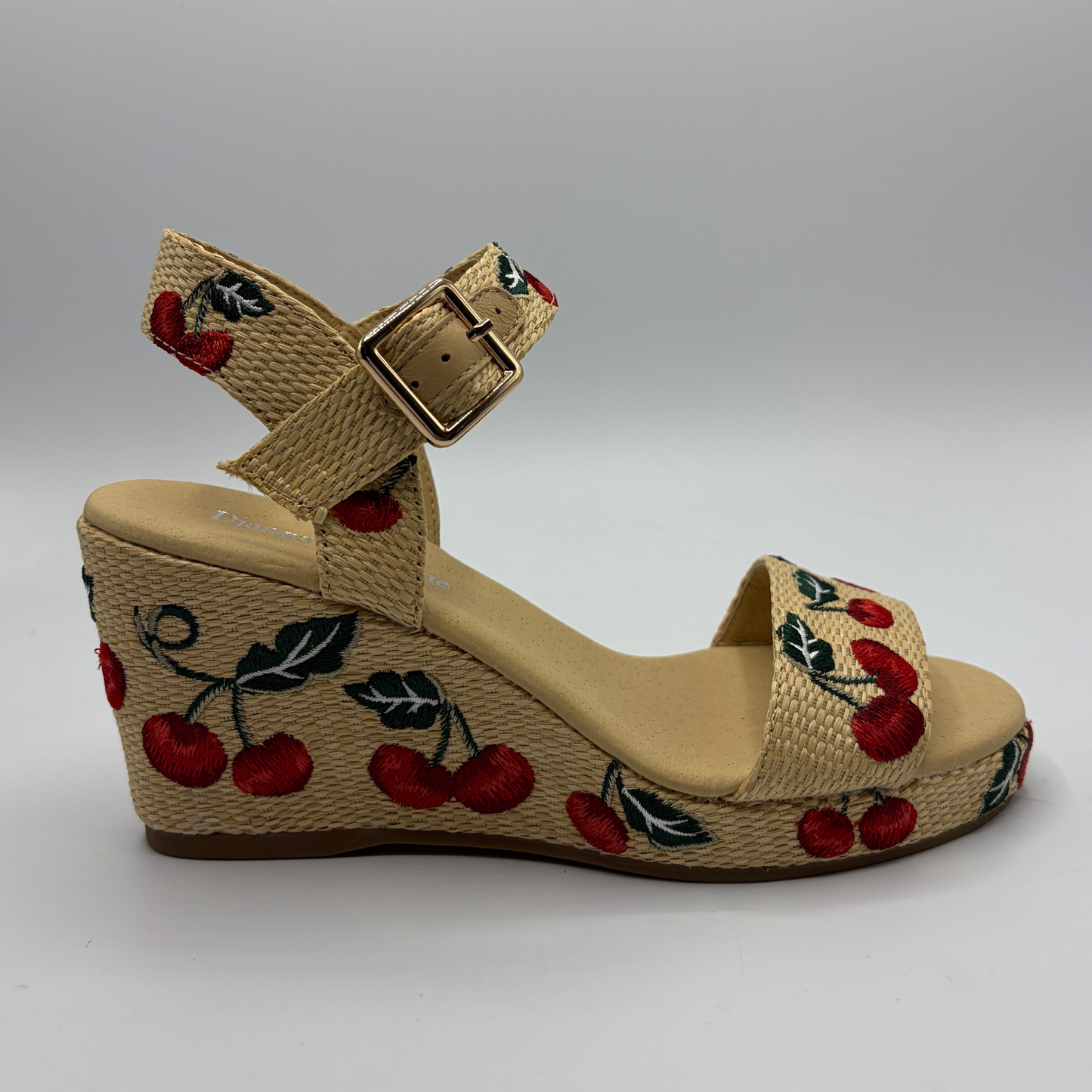 Beige wedge sandal with cherry design on a gray background