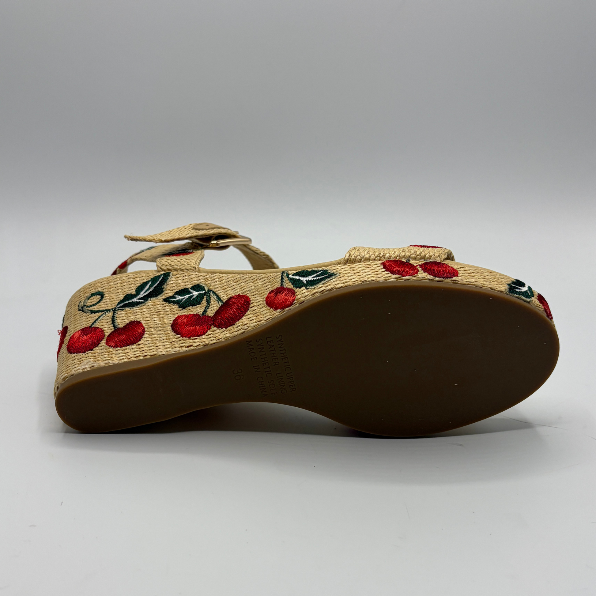 Woven sandal with cherry design on a gray background