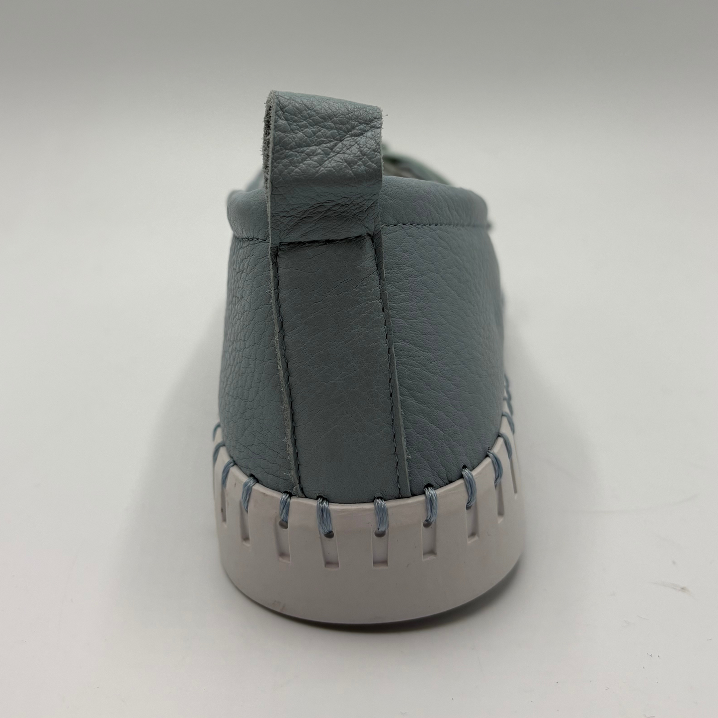 Gray slip-on shoe with a white sole on a light gray background