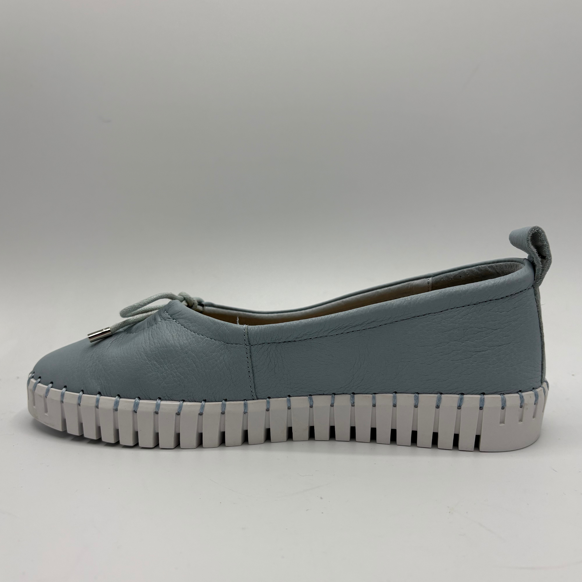 Blue slip-on shoe with a textured sole on a white background