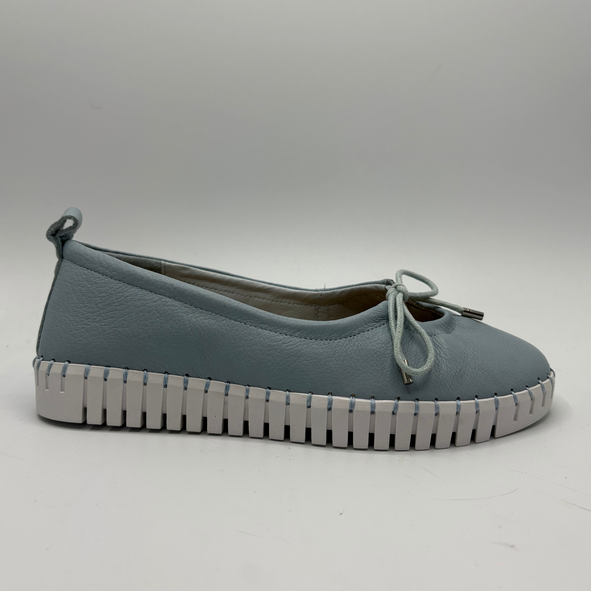 Blue shoe with a white sole on a gray background
