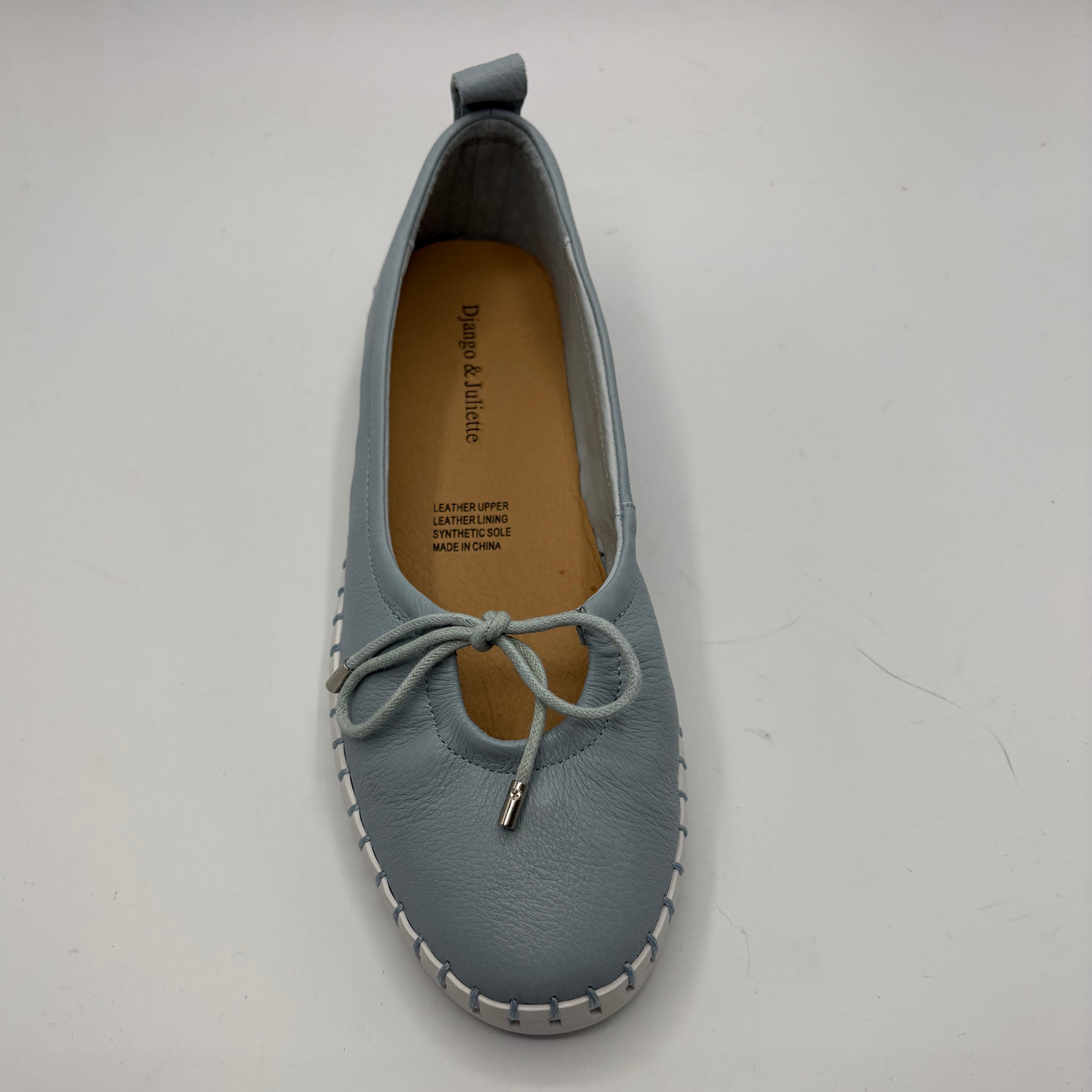 Blue leather shoe with a white sole on a light gray background
