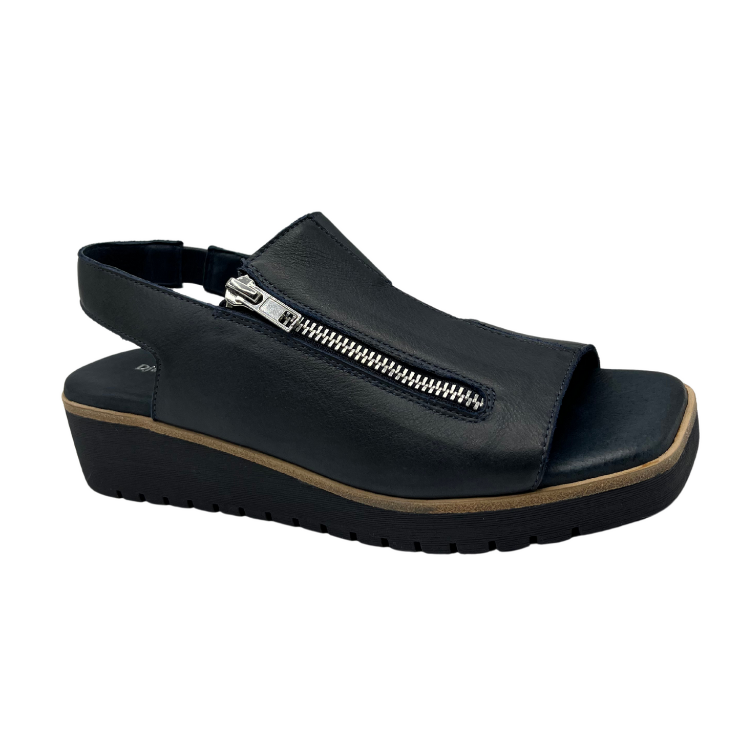 Angled view of navy leather sandal with a silver size zipper, square toe, low wedge heel and sling back strap.