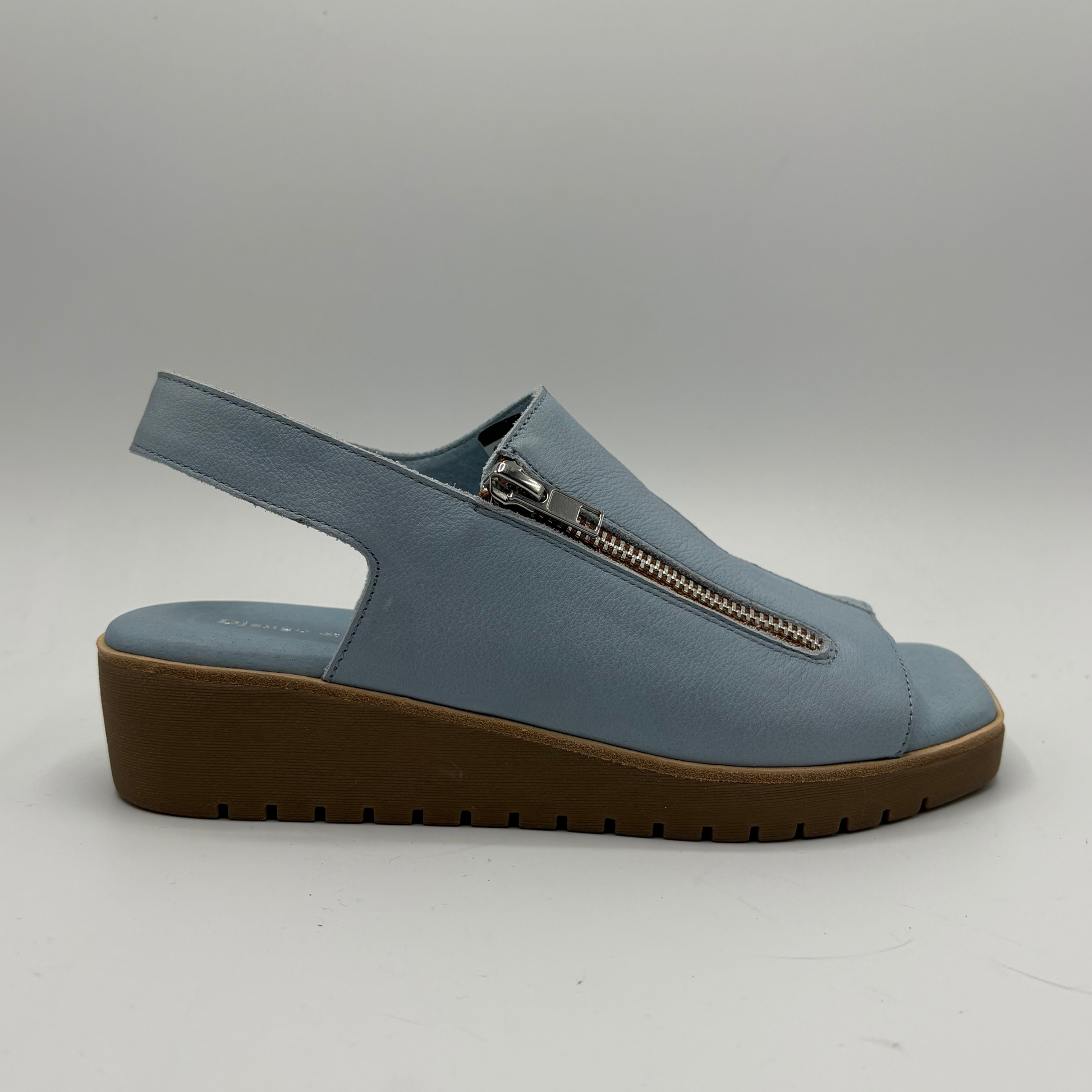 Blue sandal with a brown sole on a gray background