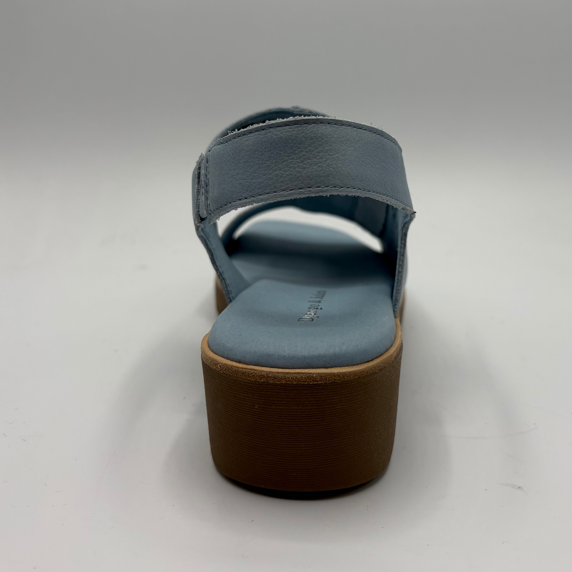 Blue sandal with a brown sole on a gray background