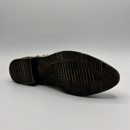 Dark brown shoe sole on a light gray background