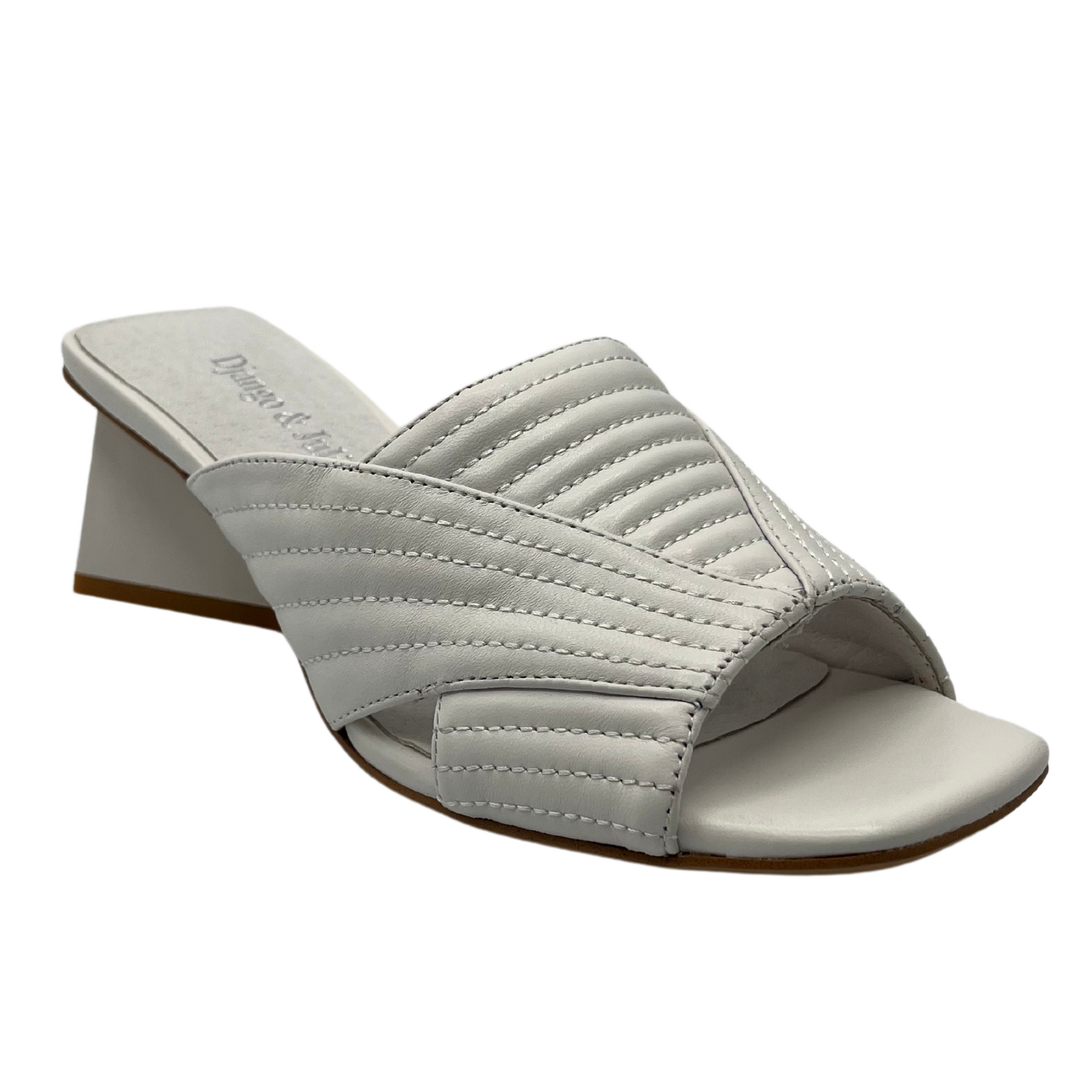 45 degree angled view of white leather sandal with square toe and triangular heel