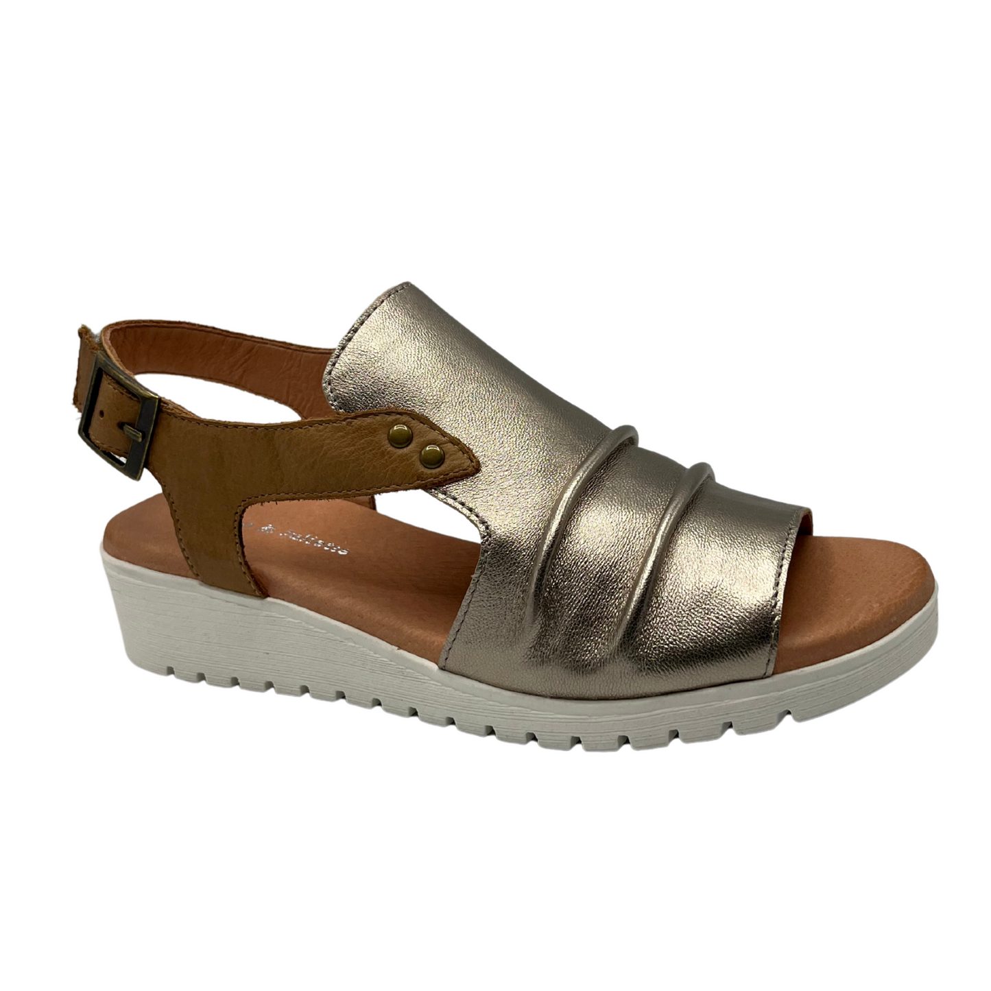 Angled view of leather sandal with a champagne gold upper and adjustable tan leather strap. Low wedge heel and rounded peep toe.