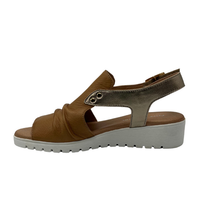 Left facing view of brown leather sandal with low wedge heel and gold slingback strap