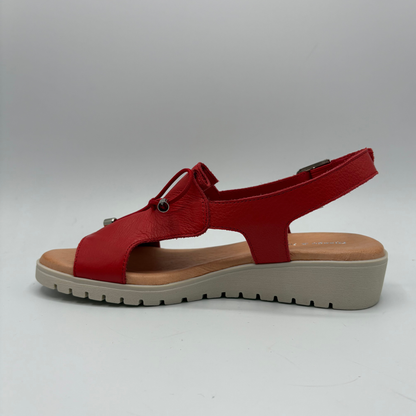 Red sandal with a beige sole on a white background