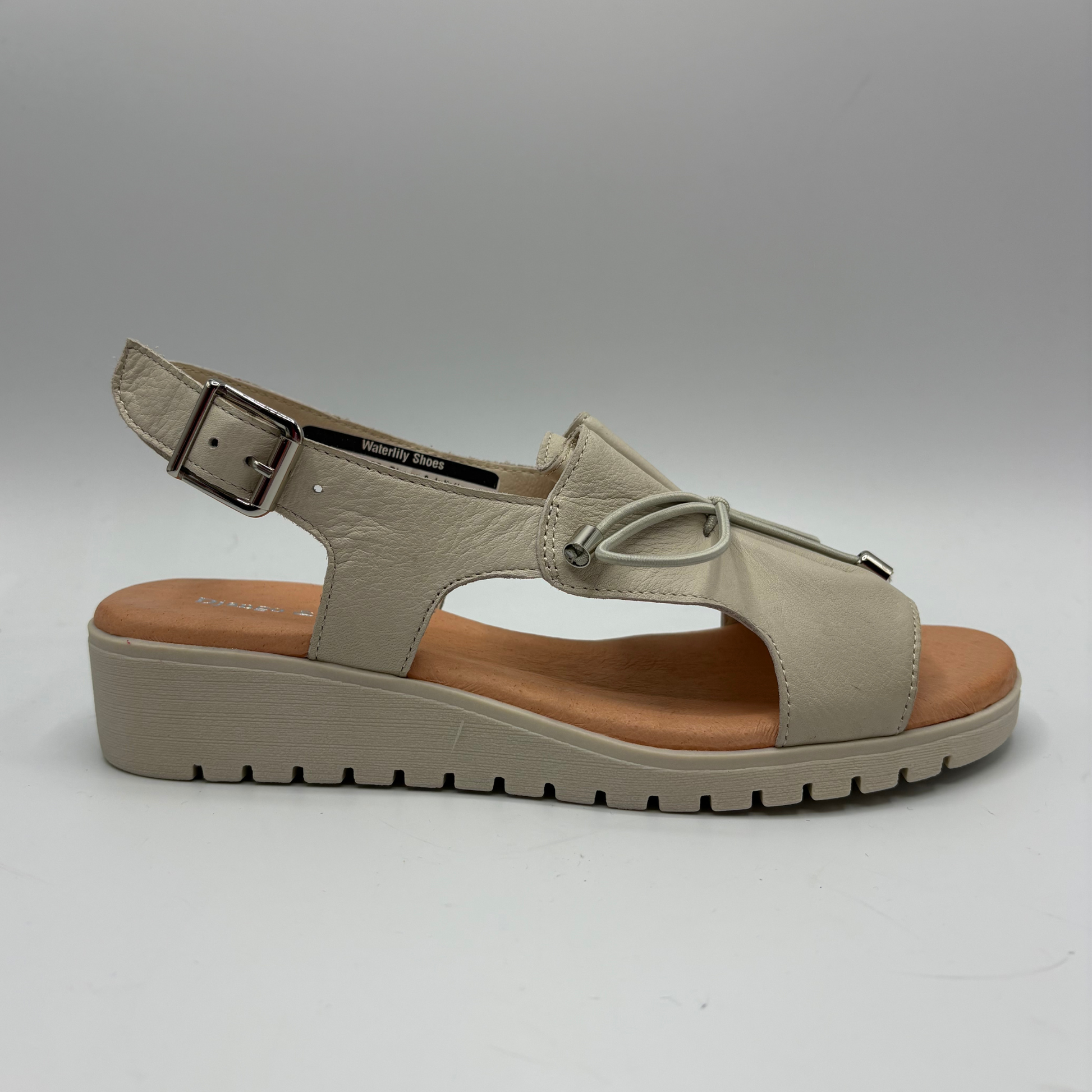 Beige sandal with a brown sole on a gray background