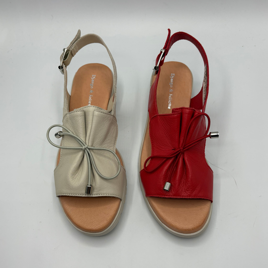 Pair of beige and red sandals on a white background