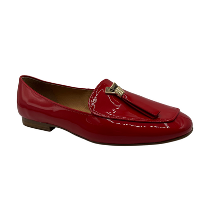 Angled view of a red patent leather loafer with a 0.8" heel and a gold and red tassel accent on the toe box.