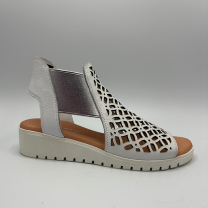 White sandal with cut-out design on a gray background