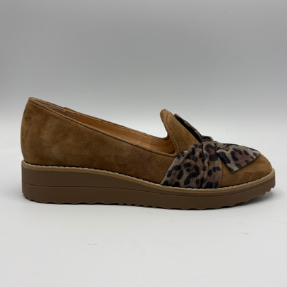 A single women's slip-on wedge shoe in brown suede with a leopard-print fabric bow detail across the vamp, shown in profile against a neutral gray background.