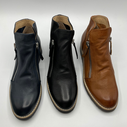 View of three short boots. Left is Navy, middle is black and the right is a light brown. All have a double zipper entry and a rounded toe