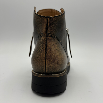 A single ankle boot shown from the back on a light gray studio background. The boot has a distressed metallic bronze-brown leather upper with a black sole and side zipper detail.