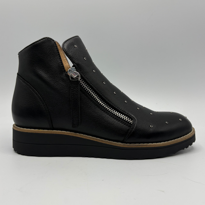 A black leather ankle boot with a side zipper, silver studs, and a brown platform sole, shown from a side profile on a light gray background.