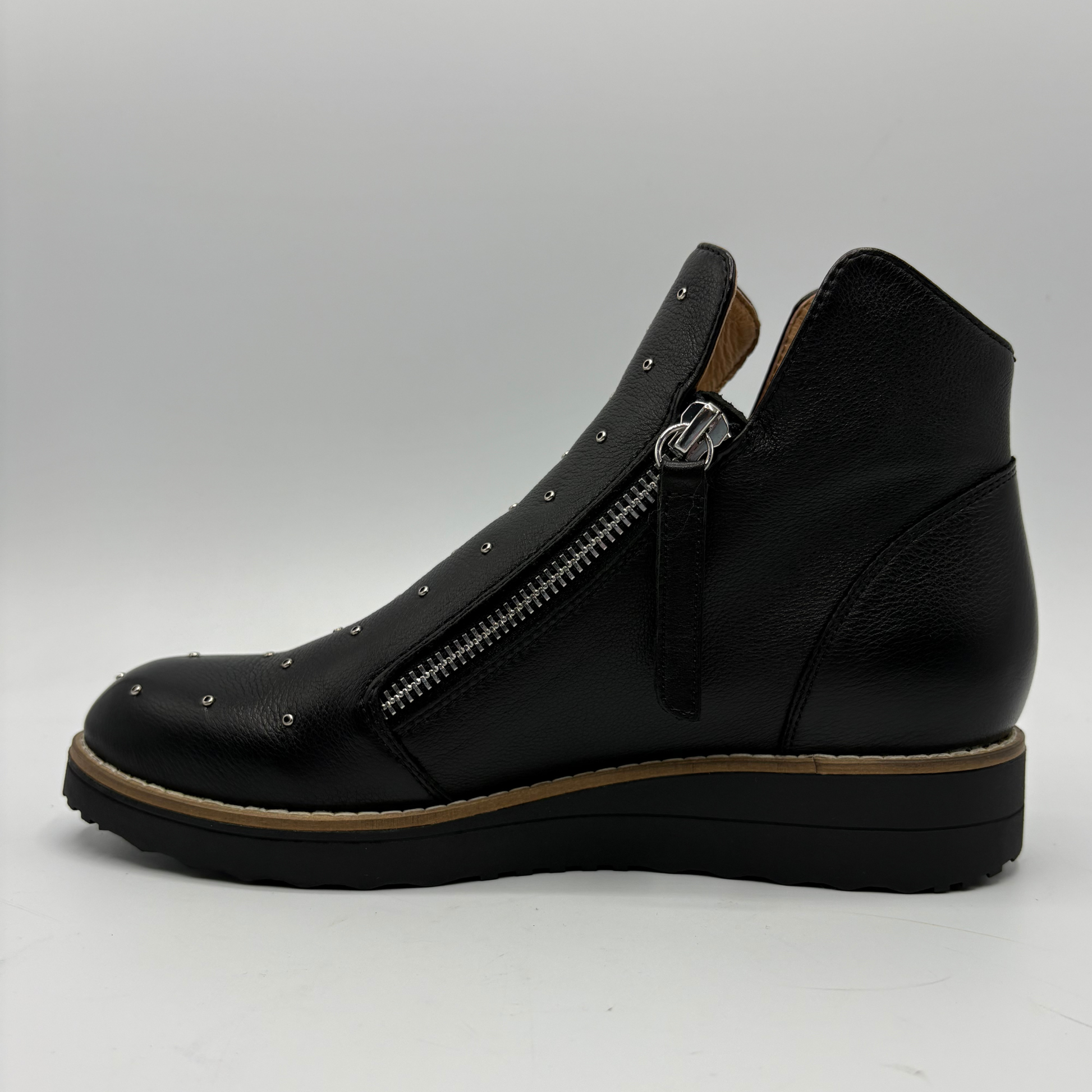 A black leather ankle boot with a side zipper, metal studs, and a chunky platform sole, shown from a side profile view against a light gray background.