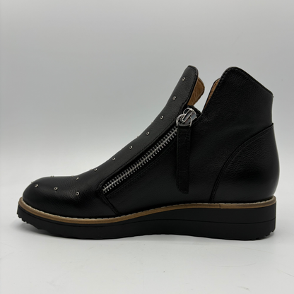 A black leather ankle boot with a side zipper, metal studs, and a chunky platform sole, shown from a side profile view against a light gray background.