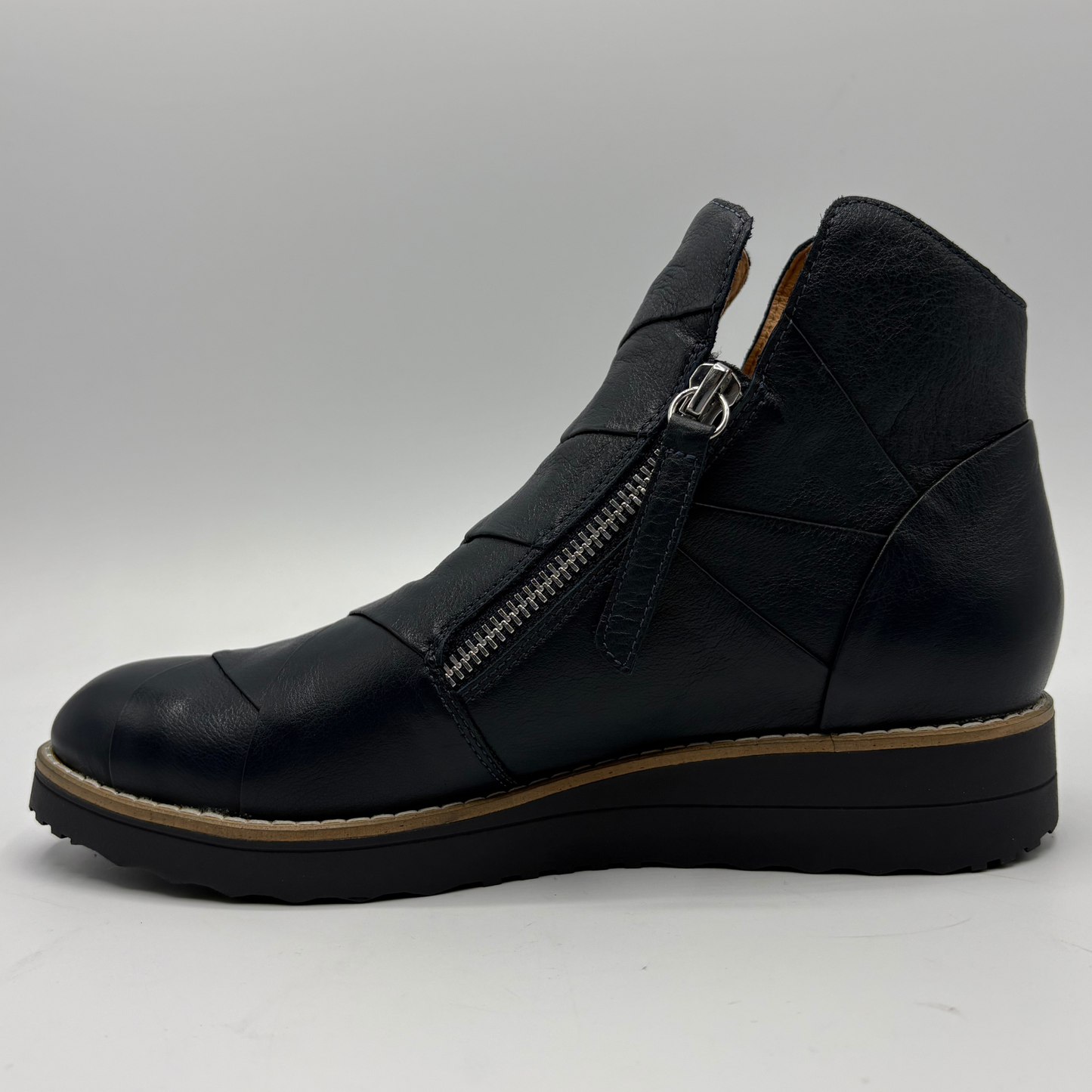 A black leather ankle boot with a side zipper, shown in profile against a light gray background.