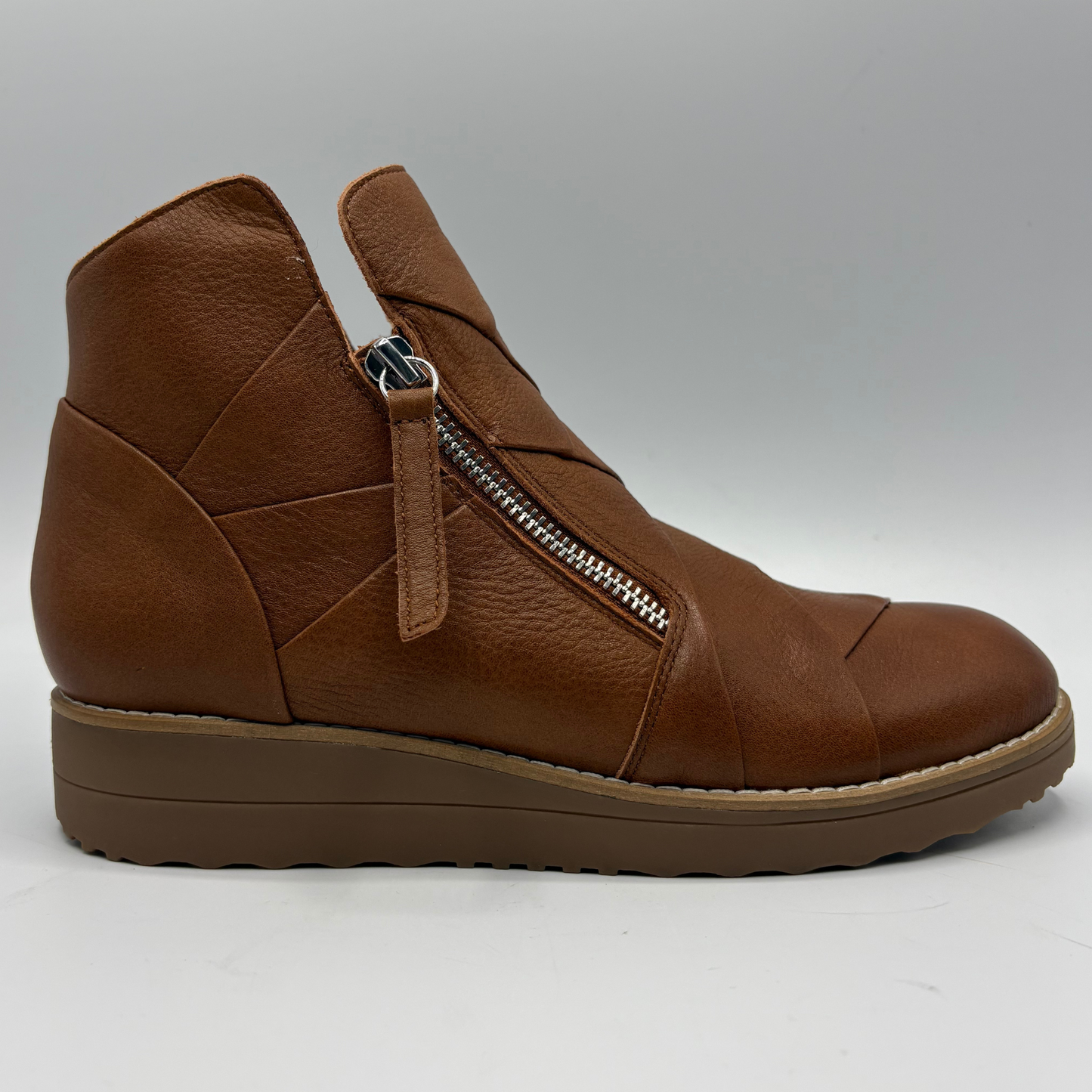 A brown leather ankle boot with a side zipper, shown in a side profile view against a neutral gray background.