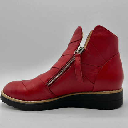Red leather ankle boot with a zipper on a gray background