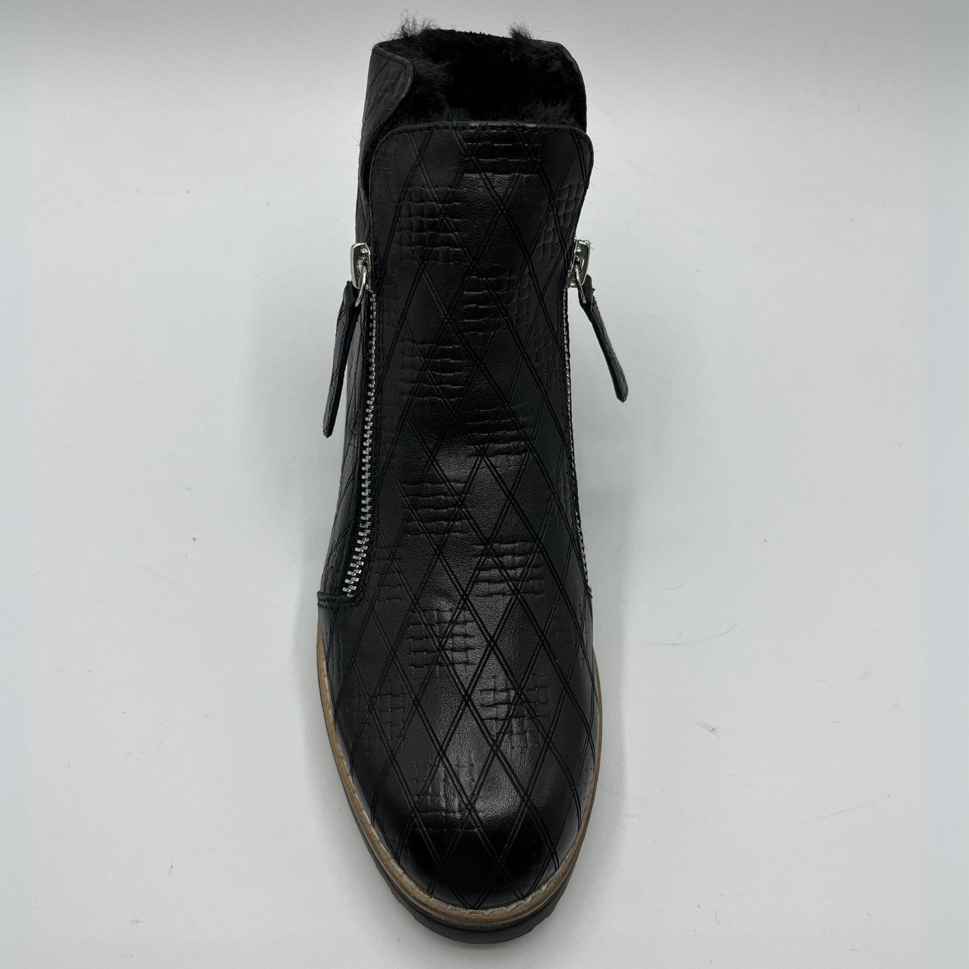 Black quilted ankle boot with zippers on a white background