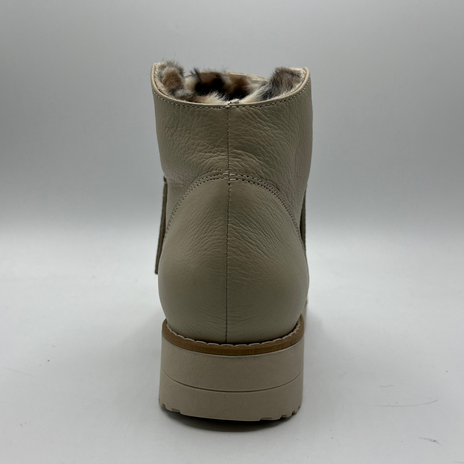 Beige ankle boot with faux fur lining on a white background
