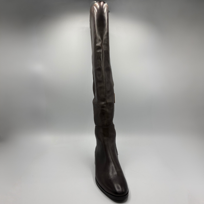 A single dark brown leather knee-high boot with a pointed toe and low black heel, photographed against a neutral gray studio background.