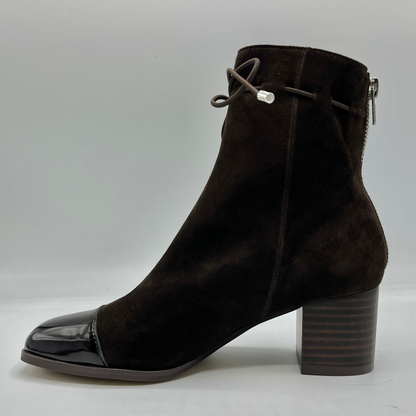 Left facing view of a chocolate leather with a chocolate patent leather toe cap. Stacked heel and unique tie up ankle