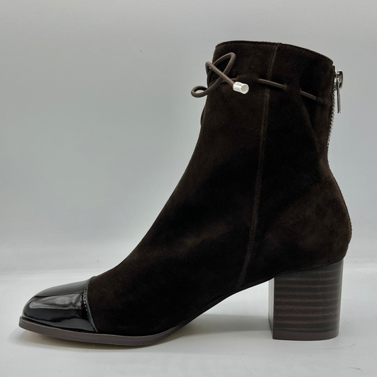 Left facing view of a chocolate leather with a chocolate patent leather toe cap. Stacked heel and unique tie up ankle