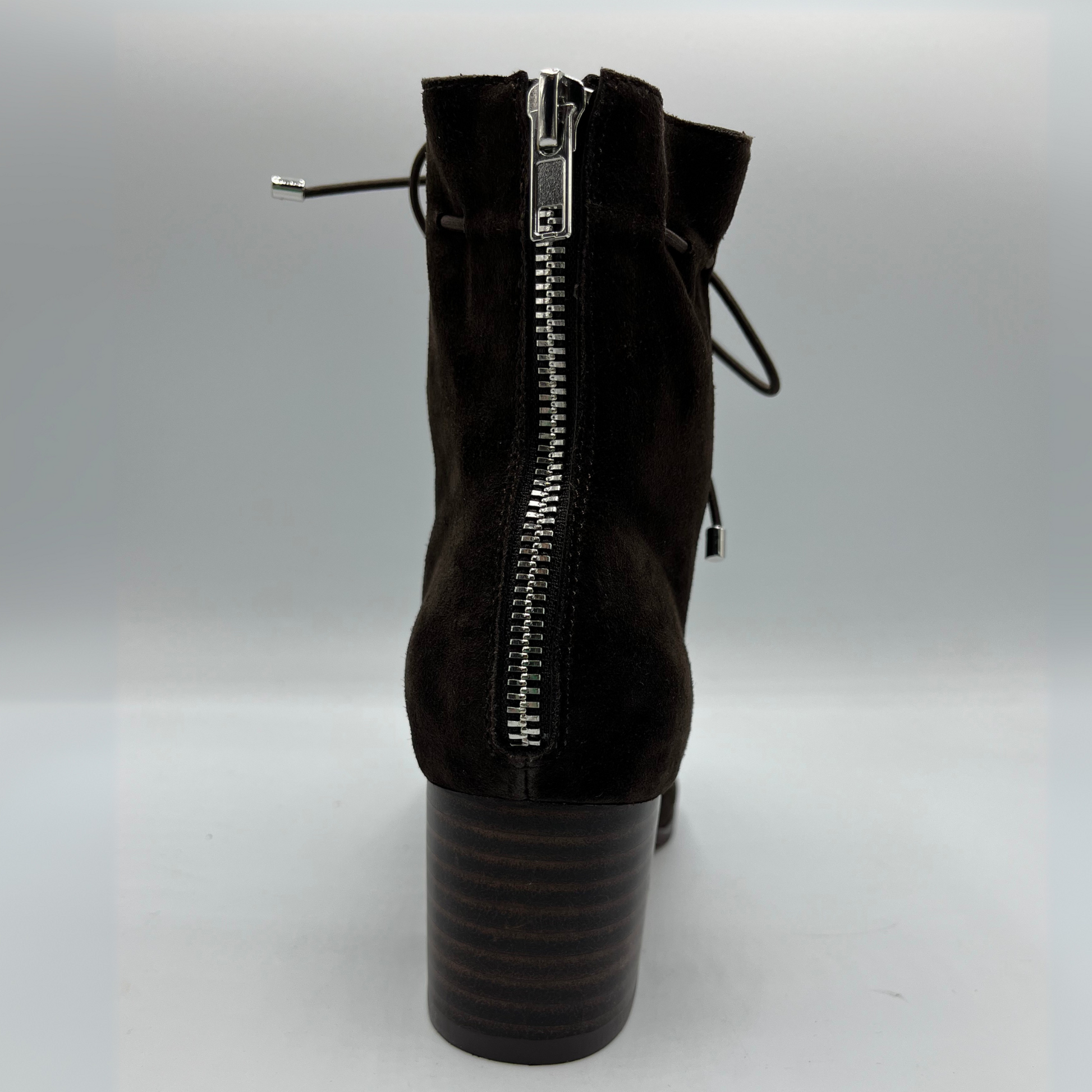 Back view of a chocolate leather with a chocolate patent leather toe cap. Stacked heel and unique tie up ankle