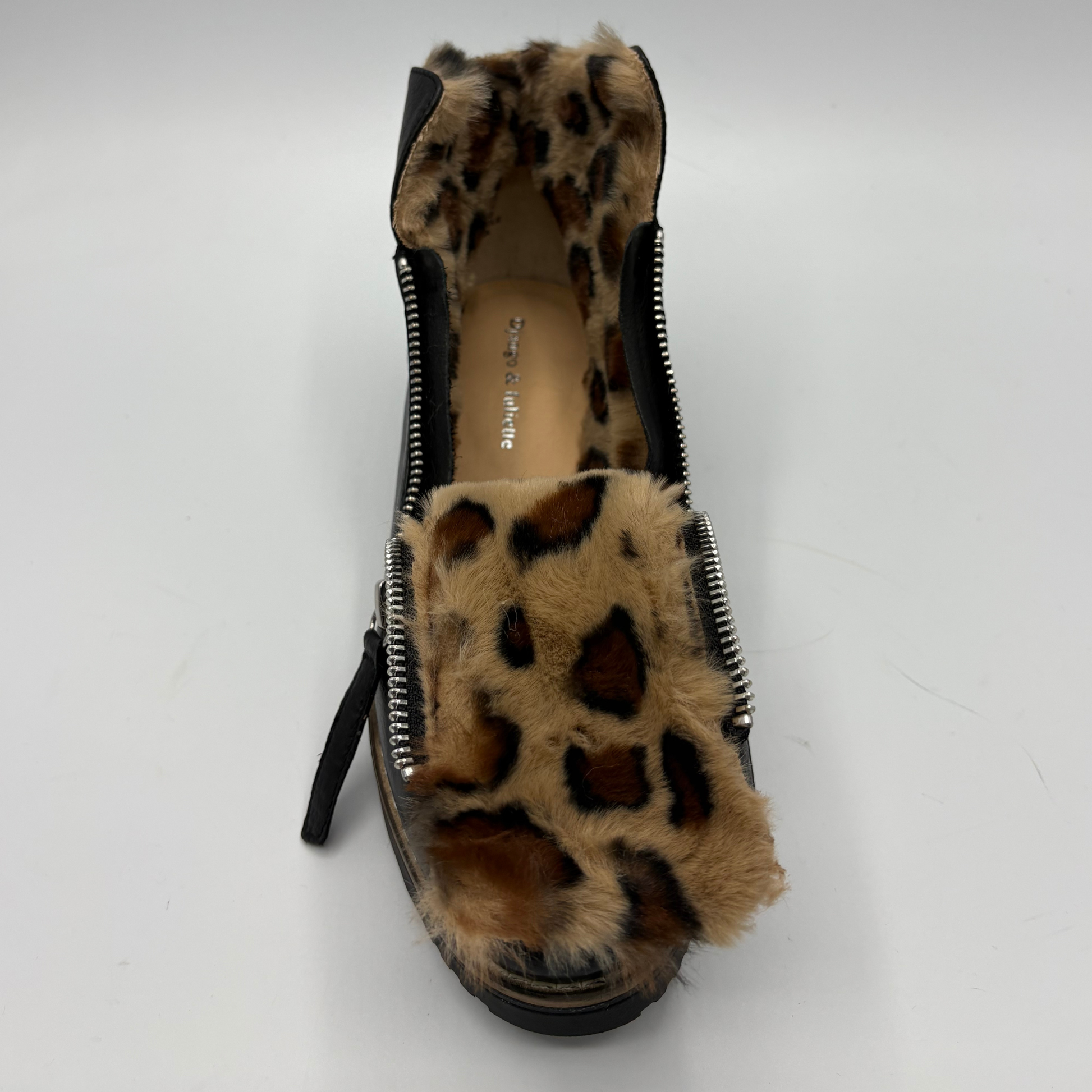 A single short boot with a leopard print faux fur lining and black side panels, photographed from a top-down angle on a light gray background.