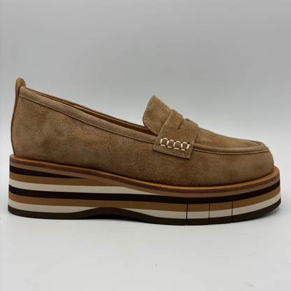 A single brown suede platform loafer with a stacked multi-colored platform sole and a small gold-tone chain detail on the strap, shown against a neutral gray background.