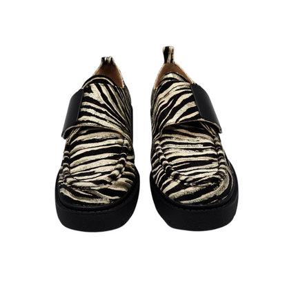 Front view of a pair of leather zebra print loafers. Velcro strap, pull on heel tab, rounded toe and leather lining.