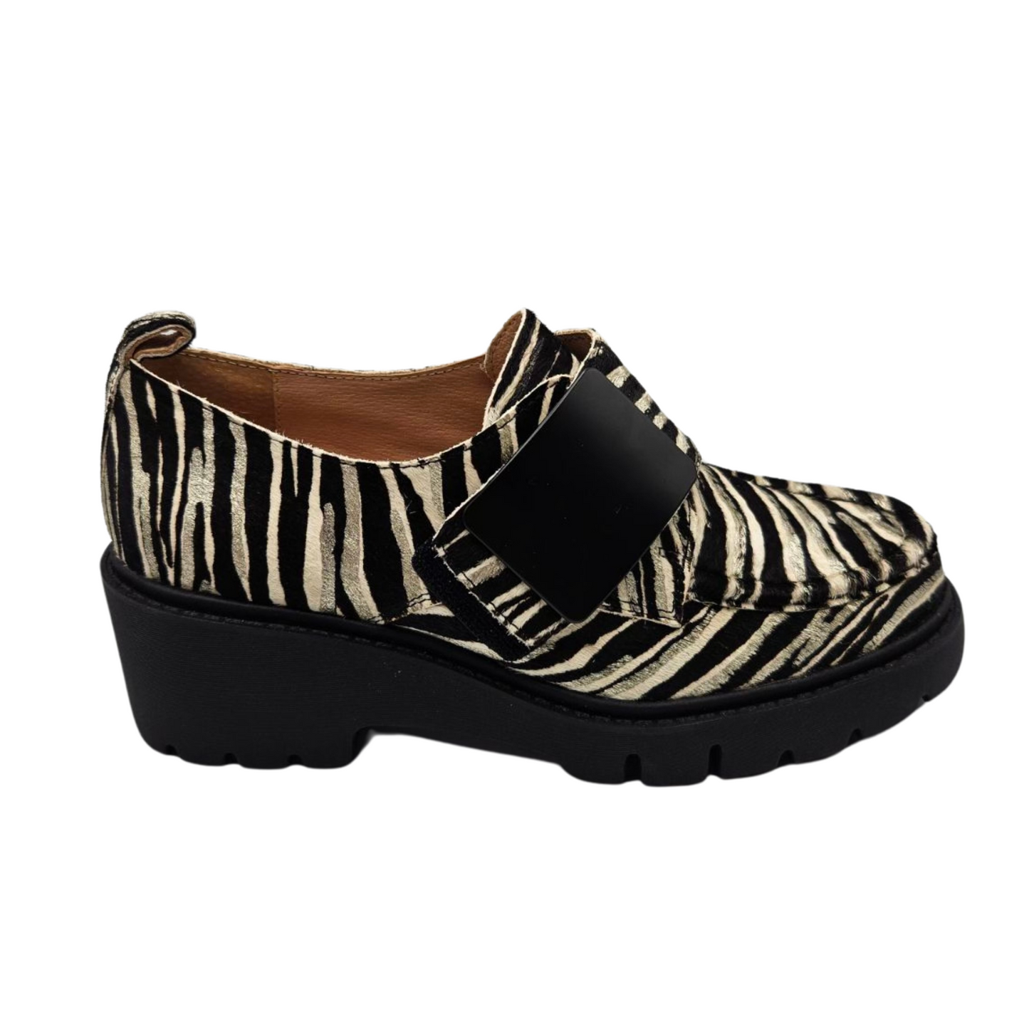 Right facing view of leather zebra print loafer. Velcro strap, pull on heel tab, rounded toe and leather lining.