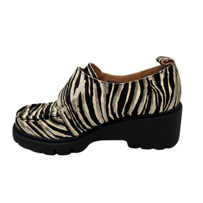 Left facing view of leather zebra print loafer. Velcro strap, pull on heel tab, rounded toe and leather lining.