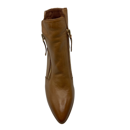 Top view of pointy toe leather boot with a gold zipper on either side of ankle
