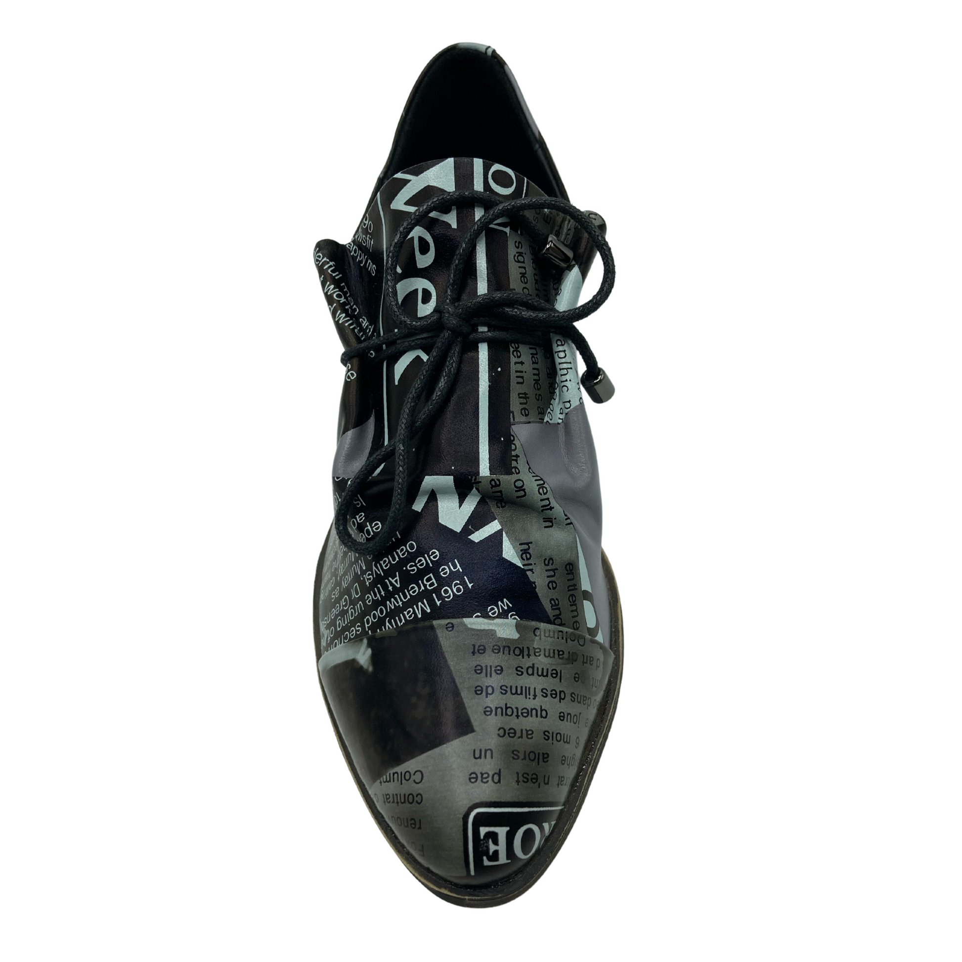 Top view of a leather shoe with newsprint design. Laces are black with shiny black aglets