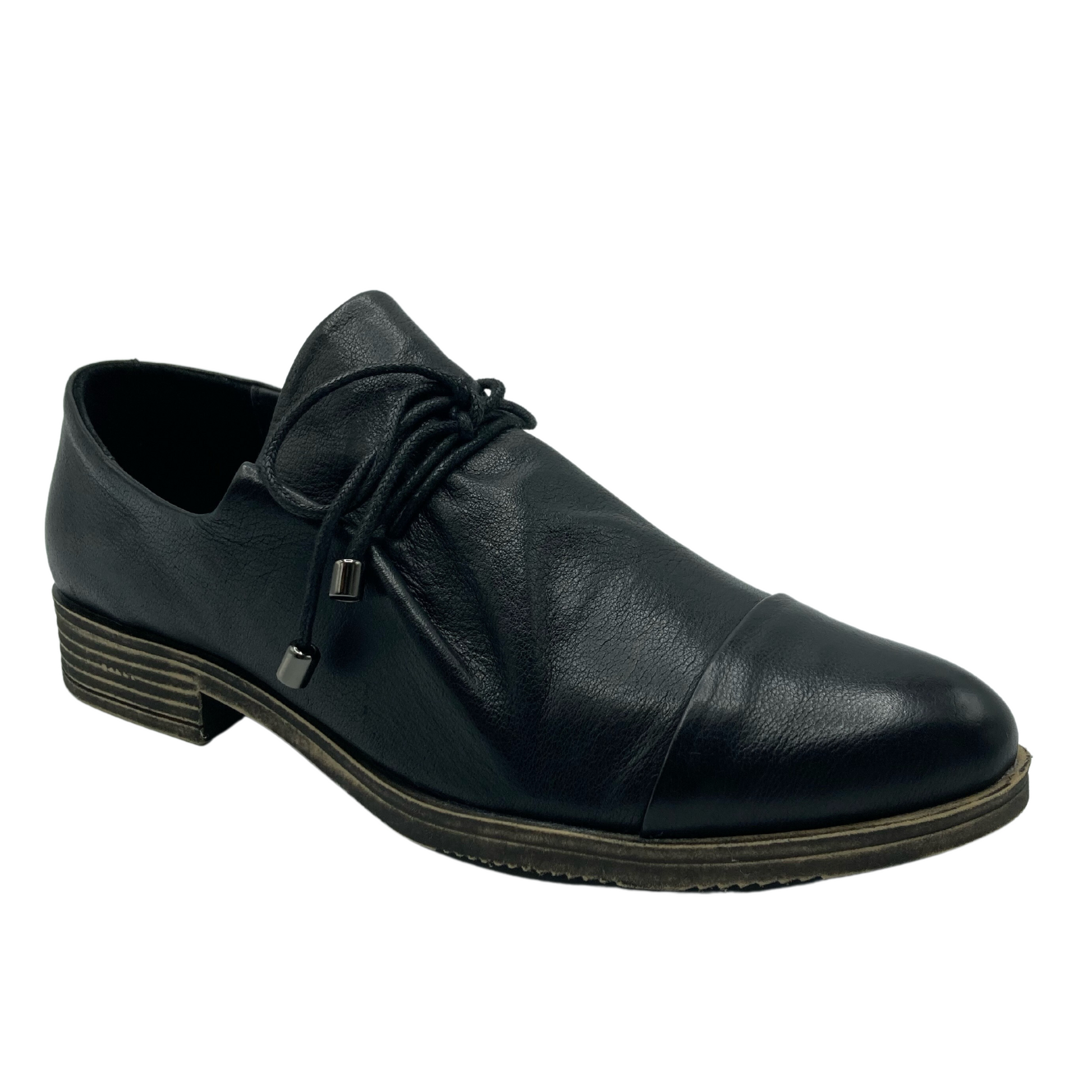 45 degree angled view of black leather shoe with black laces that have silver aglets on the ends